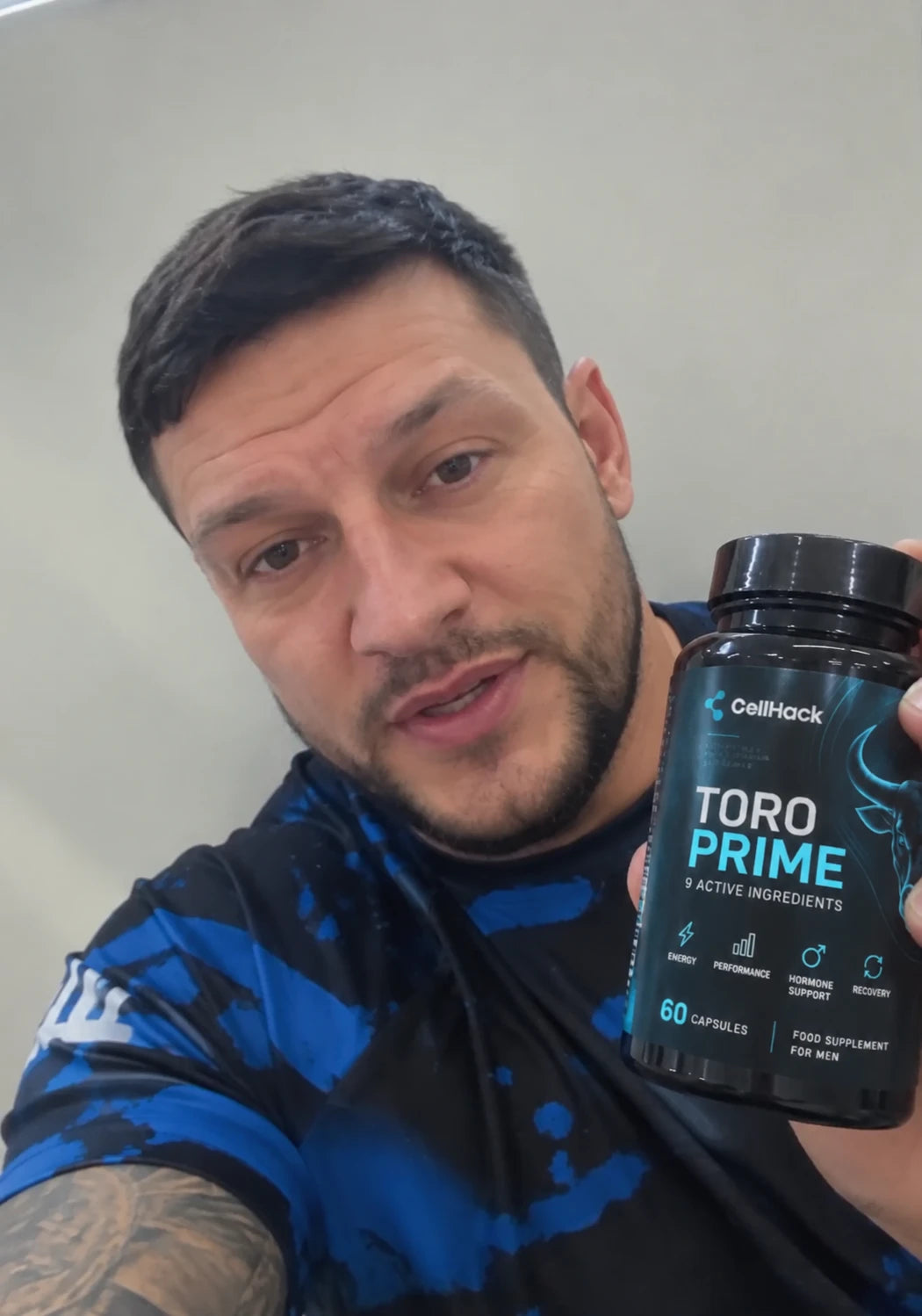 A man in a blue top holding a bottle of Toro Prime