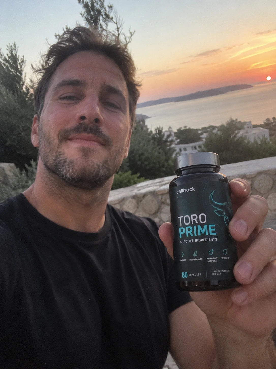 A man at sunset holding a bottle of Toro Prime